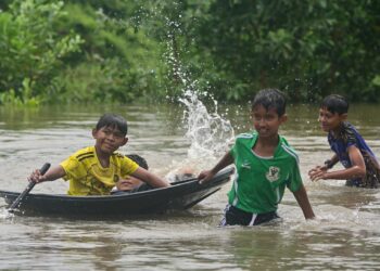 SEKUMPULAN kanak-kanak bermain air banjir yang semakin surut di pekarangan rumah mereka di Kampung Atas Tol, Kuala Terengganu, Terengganu. - UTUSAN/PUQTRA HAIRRY