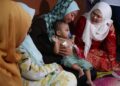 SALBIAH Mohamed (kanan) melihat keadaan bayi 14 bulan yang menghidap ketumbuhan di Bandar Lahat Baru, Ipoh hari ini. -UTUSAN/LIYANA RAMLI