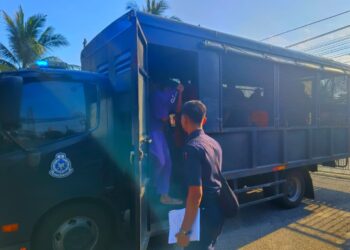 SUSPEK (depan) diiringi anggota polis semasa hadir ke mahkamah untuk mendapatkan perintah tahanan reman di Bachok, Kelantan. - UTUSAN/YATIMIN ABDULLAH