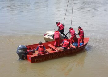 ANGGOTA bomba menjalankan operasi menarik kereta Proton Waja yang terjatuh ke dalam Sungai Perak di Kampung Baru Layang-layang Kanan, Parit hari ini.