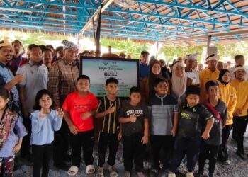 SHAMSUL Anuar Nasarah (empat dari kiri) dan Azura Abidin (lima dari kanan) bergambar bersama orang ramai pada Peluncuran Kampung Angkat Madani JBSN di Pulau Temelong, Kampung Temelong dekat Lenggong hari ini.