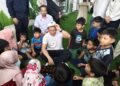 NGA Kor Ming menyantuni kanak-kanak PPR Pangsapuri Seri Kepayang, Ipoh ketika merasmikan Ruang Komuniti (Rukom) ke-100 di kawasan tersebut hari ini.