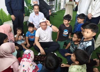 NGA Kor Ming menyantuni kanak-kanak PPR Pangsapuri Seri Kepayang, Ipoh ketika merasmikan Ruang Komuniti (Rukom) ke-100 di kawasan tersebut hari ini.