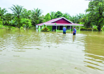 JALAN masuk ke Kampung Selat Manggis dan Kampung Sungai Kerawai di Teluk Intan yang dinaiki banjir ketika tinjauan semalam. – UTUSAN/AIN SAFRE BIDIN