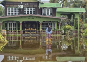 SEORANG penduduk meredah banjir di halaman rumahnya ketika tinjauan di Kampung Sungai Tiang Darat di Bagan Datuk, Perak, semalam. – UTUSAN/AIN SAFRE BIDIN