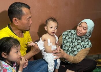 MOHD. Fauzi Saad dan Anis Azwanie Azmi bersama Firas Affan yang disahkan menghidap penyakit germ cell tumor ketika ditemui di rumah mereka di Bandar Lahat Baru, Ipoh, semalam.