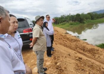 JAMAWI Jaafar (depan) melihat pelan jajaran rancangan tebatan banjir Sungai Padas, Tenom, Sabah, hari ini. - UTUSAN/HARDY JOE