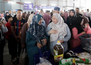 FUZIAH Salleh (kanan) beramah mesra dengan orang ramai semasa menghadiri Program Jualan Rahmah Madani di Tapak Futsal Kampung Neting, Tumpat, Kelantan. - UTUSAN/KAMARUL BISMI KAMARUZAMAN