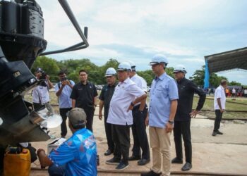 MOHAMAD Sabu (tengah) meninjau pekerja limbungan menyelenggara sebuah bot yang menggunakan perkhidmatan Limbungan Kapal PNK Kuala Kedah di Teluk Layang, Alor Setar. - UTUSAN/ SHAHIR NOORDIN
