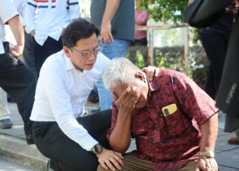 SHAHROL Shiro (kiri) ketika menenangkan seorang penyokong Datuk Seri Najib Tun Razak yang sebak selepas keputusan Mahkamah Tinggi, di sini hari ini. - UTUSAN/AMIR KHALID