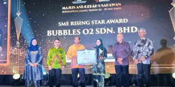 RAHMAN Mohd Din (tiga dari kiri) menyampaikan anugerah berkategori kepada penerima bersama Samad Majid Zain (dua dari kanan) dalam Majlis Anugerah Usahawan Bersempena Ulang Tahun Ke-20 SME Bank di sini, semalam.