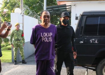 TERTUDUH semasa dibawa oleh polis untuk prosiding perbicaraan di Mahkamah Majistret, Tanah Merah, Kelantan. - UTUSAN/KAMARUL BISMI KAMARUZAMAN