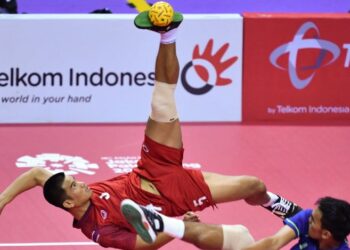 Bekas bintang sepak takraw Thailand, Pornchai Kaokaew (kiri) melakukan libasan sambil dihadang pemain Malaysia, Mohammad Syahir Mohd. Rosdi dalam aksi final regu Sukan Asia Palembang 2018. - AFP