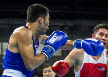 Petinju Thailand, Bunjong Sinsiri (kiri) mengasak wakil Malaysia, Mohd. Farid Muhammad Ariff Aiman dalam aksi suku akhir kategori 69 kilogram Sukan SEA 2025 Thailand di Bangkok, baru-baru ini. - AFP