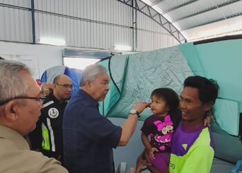 AHMAD Zahid Hamidi menyantuni mangsa banjir yang ditempatkan di PPS Dewan Pejabat Tanah dan Daerah Bagan Datuk.