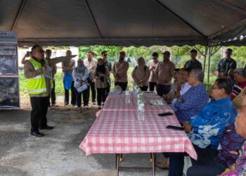 AHMAD Zahid Hamidi (kanan) mendengar taklimat mengenai Projek Rancangan Tebatan Banjir (RTB) Bagan Datuk ketika lawatan ke Kampung Sungai Balai Baroh di Bagan Datuk hari ini.