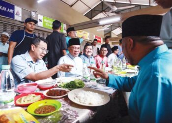 Anwar Ibrahim menyantuni orang ramai sebelum makan tengah hari di Medan Selera Taman Dato’ Harun, Petaling Jaya, semalam. – utusan/AFIQ RAZALI