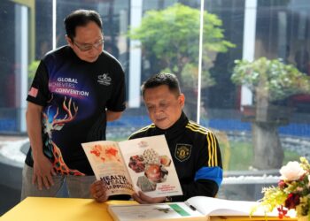 TUANKU Syed Faizuddin Putra Jamalullail sedang membaca risalah maklumat mengenai Gano Excel Industries Sdn. Bhd., selepas berkenan menandatangani buku pelawat kilang tersebut di Kampung Cherok Mokkan, Mukim Hosba, Kedah.