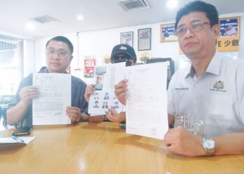 SIAH (tengah) menunjukkan surat ugutan ah long di Taman Maju Jaya, Johor Bahru.