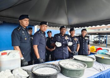 HUSSEIN Omar Khan (tengah) menunjukkan ketulan simen mengandungi dadah jenis MDMA yang dirampas dalam serbuan di stor penyimpanan dadah yang beroperasi di sebuah rumah banglo di Jalan Tun Dr Ismail, Ipoh, hari ini.