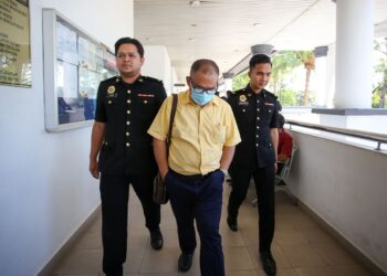 SUHAILI Othman dikawal pegawai Suruhanjaya Pencegahan Rasuah Malaysia selepas menghadapi dua pertuduhan membuat tuntutan perjalanan palsu di Mahkamah Sesyen Alor Setar, hari ini. - UTUSAN/ SHAHIR NOORDIN