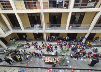 SEBAHAGIAN warga asing yang ditahan dan diperiksa dalam operasi bersepadu di sebuah tapak pembinaan di Nilai, Seremban semalam. -GAMBAR / IHSAN POLIS