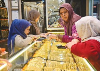 PELANGGAN melihat koleksi barangan kemas di sebuah kedai di Pasar Payang, Kuala Terengganu. – UTUSAN/PUQTRA HAIRRY