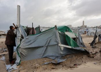 SEORANG lelaki Palestin membaiki khemahnya yang rosak dipukul angin kencang di kawasan tepi pantai di Gaza City.-AFP
