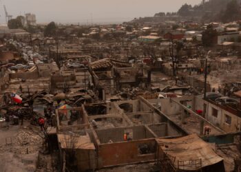 Penduduk kejiranan Gabriela Mistral membersihkan runtuhan dan sisa kebakaran di rumah masing-masing yang hangus selepas kebakaran hutan melanda Lirquén, Chile.-AFP