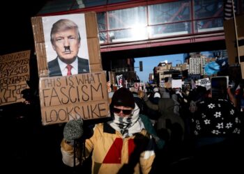 SEORANG penunjuk perasaan memegang papan tanda mengecam Donald Trump ketika berhimpun dalam perarakan Hari Kebenaran dan Kebebasan di Minneapolis, Minnesota.-AFP