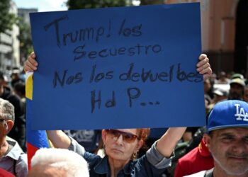 PENYOKONG Presiden Nicolas Maduro memegang plakad yang bertulis 'Trump menculik mereka' ketika berhimpun di Caracas selepas pasukan AS menangkap pemimpin itu, kelmarin.- AFP