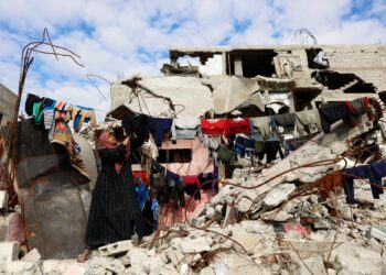 SEORANG wanita Palestin menyidai pakaian di tempat tinggal sementara di tengah-tengah runtuhan rumah dan perniagaan yang musnah di kem pelarian Jabalia, utara Gaza.-AFP