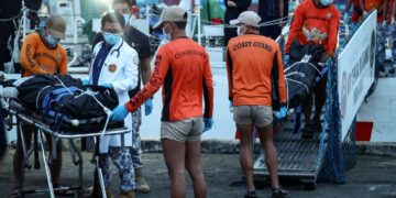 ANGGOTA Pengawal Pantai Filipina membawa beg mayat mangsa yang terkorban dalam insiden feri karam di Pelabuhan Manila, semalam.- AGENSI