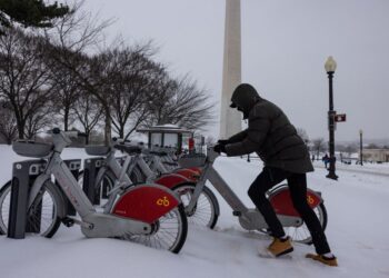 SEORANG lelaki cuba mengeluarkan basikal yang tersekat dalam salji tebal di stesen Capitol Bikeshare berhampiran Monumen Washington.-AFP