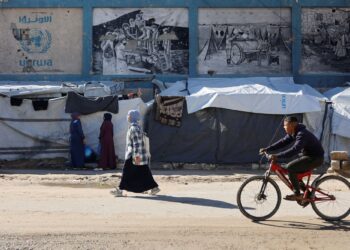 PENDUDUK Palestin melepasi khemah sementara yang didirikan oleh keluarga Palestin yang dipindahkan berhampiran ibu pejabat UNRWA di Gaza City.-AFP