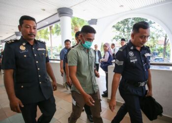 JUFRI Zulkifli dikawal anggota polis dan penguatkuasa SWCorp selepas dikenakan denda RM300 kerana membuang puntung rokok di Mahkamah Sesyen Alor Setar, hari ini. - UTUSAN/ SHAHIR NOORDIN