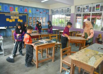 MURID-murid dan guru bersama-sama bergotong-royong membersih dan menghias kelas masing-masing sebagai persiapan menjelang sesi baharu persekolahan selepas sekolah berkenaan terjejas teruk akibat banjir di Sekolah Tengku Budriah (STB), Arau, Perlis semalam.-UTUSAN/IZLIZAN OTHMAN