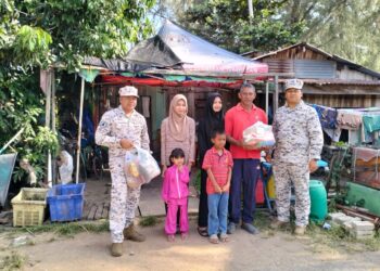 MOHD. Yuskhairul Alhasis Mat Yunus (kiri) menyerahkan sumbangan barang keperluan dapur kepada Hashim Jusoh (dua dari kanan) di Kampung Pantai Geting Tumpat, Kelantan. - UTUSAN/ ROHANA ISMAIL