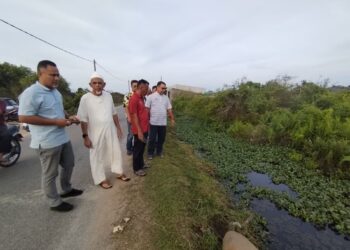 PENDUDUK menunjukkan air di dalam parit yang tidak dapat mengalir ke muka kuala dan menjadi punca banjir kilat di sekitar Kampung Pachakan, Besut, Terengganu. – UTUSAN/WAN ZURATIKAH IFFAH WAN ZULKIFLI