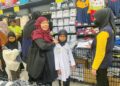 NUR Farhana Nasuha (tengah) mencuba pakaian sekolah pada program sumbangan keperluan persekolah anjuran Thirdforce Pasir Mas di bawah Yayasan Raja Shamri di Mydin Mall Tunjong, Kota Bharu, Kelantan. – UTUSAN/ROSMIZAN RESDI