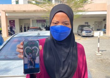 NOR Hamiza Halid menunjukkan gambar percutian mereka empat beranak di Cameron Highland, baru-baru ini ketika ditemui di pekarangan Jabatan Forensik HSB di Alor Setar, Kedah.