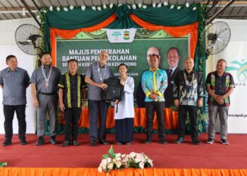 AHMAD Parveez Ghulam Kadir (empat dari kiri diiringi Guru Besar SK Kemabong, Tenom, Mohd. Azlan Mohd. Arfan Salim (tiga dari kanan) smenyampaikan bantuan peralatan persekolahan kepada wakil pelajar sekolah tersebut semasa Majlis Penyerahan Bantuan Persekolahan Sekolah Kebangsaan Kemabong di Tenom, Sabah. 