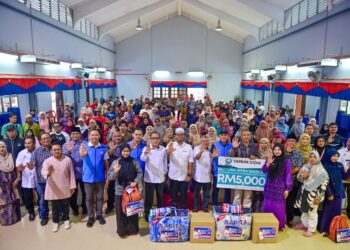 ZULKIFLI Hasan (tengah) bergambar bersama penerima bantuan pada Program Santuni Mangsa Banjir di Sekolah Menengah Kebangsaan Padang Midin, Kuala Terengganu. - UTUSAN/PUQTRA HAIRRY