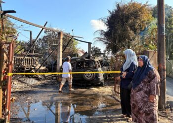 SITI Haminah Daud (kanan) melihat kawasan kediamannya yang terbakar di Langgar Kota Bharu, Kelantan hari ini.- UTUSAN/ ROSLIZA MOHAMED