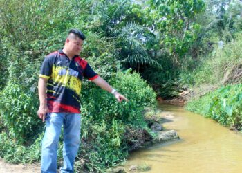 CHIEW Chin Kin menunjukkan sungai yang tercemar akibat limpahan air larut resap dari tapak pelupusan sampah berhampiran Ladang Tanah Merah, Port Dickson, Negeri Sembilan yang berlaku pada awal Januari lalu. – MINGGUAN/NOR SHAFIQAH MOHD. GHAZALI