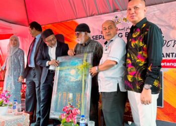 ISMAIL Embong (tengah) menyerahkan lukisan kepada Zamakhshari Muhamad (tiga dari kiri) pada program Sepetang Sepetang Bersama Legasi Ismail Embong di Balai Seni Lukis, Kota Bharu, Kelantan. – UTUSAN/ROSLIZA MOHAMED