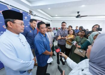 BADRUL Hisham Alias ditemui selepas menyerahkan kad pengenalan daftar lewat kepada tujuh beradik di Sungai Buaya, semalam.
– UTUSAN/AMIR KHALID