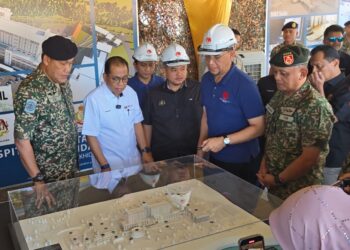 MOHAMED Khaled Nordin melihat pelan pembangunan Hospital ATM yang baharu sempena lawatan kerja beliau ke Kem Terendak, Melaka semalam. – UTUSAN/AMRAN ALI