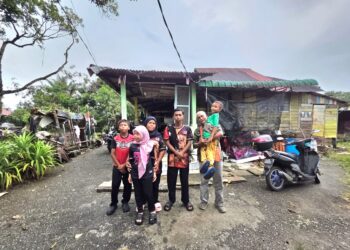 HASSAN Hashim (kanan) dan Hayati Mohamad (tiga dari kiri) bersama empat anak mereka di hadapan rumah mereka di Jalan Sungai Nibong, Teluk Intan, Perak. – UTUSAN/AIN SAFRE BIDIN