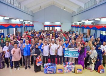 ZULKIFLI Hasan (tengah) bergambar bersama penerima bantuan pada Program Santuni Mangsa Banjir di Sekolah Menengah Kebangsaan Padang Midin, Kuala Terengganu. – MINGGUAN/PUQTRA HAIRRY